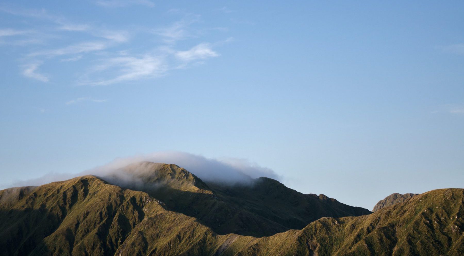 Mountains with low hanging clouds and a clear sky