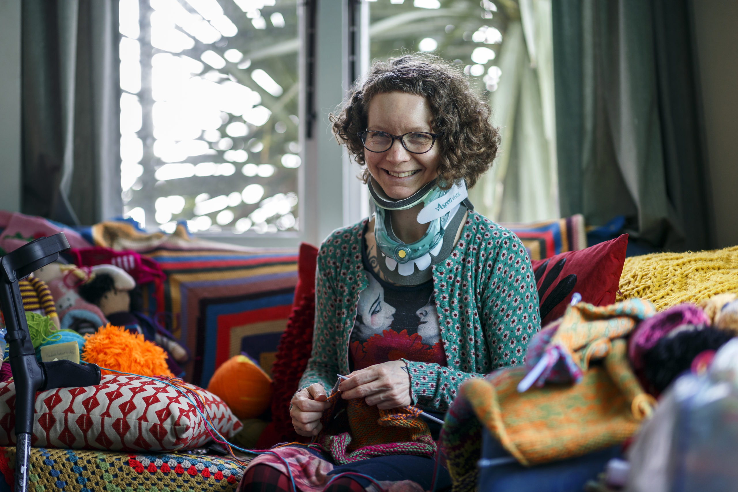 Norelle sitting in her living room knitting