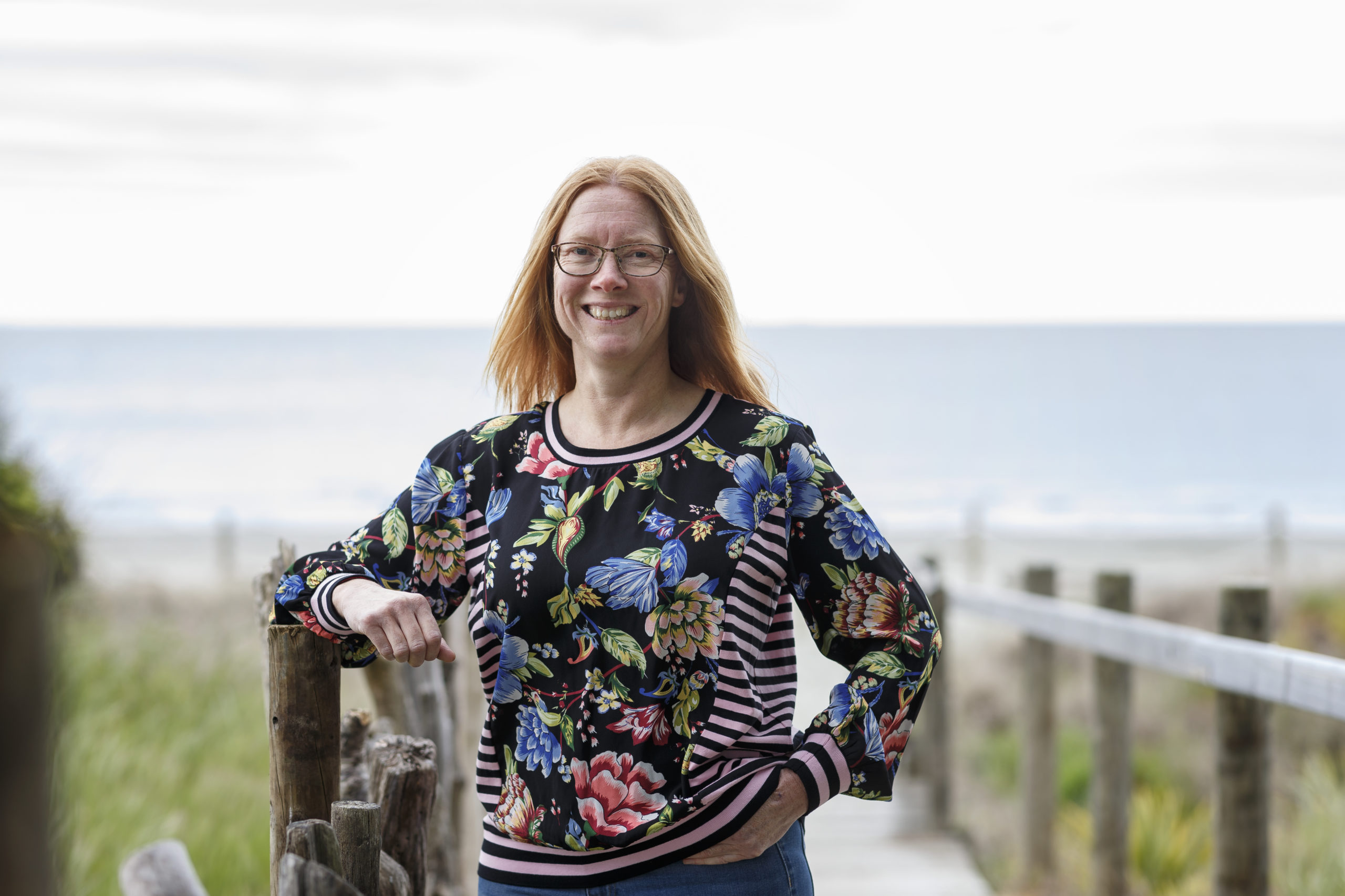 Rebecca posing for a photo in front of a beach setting